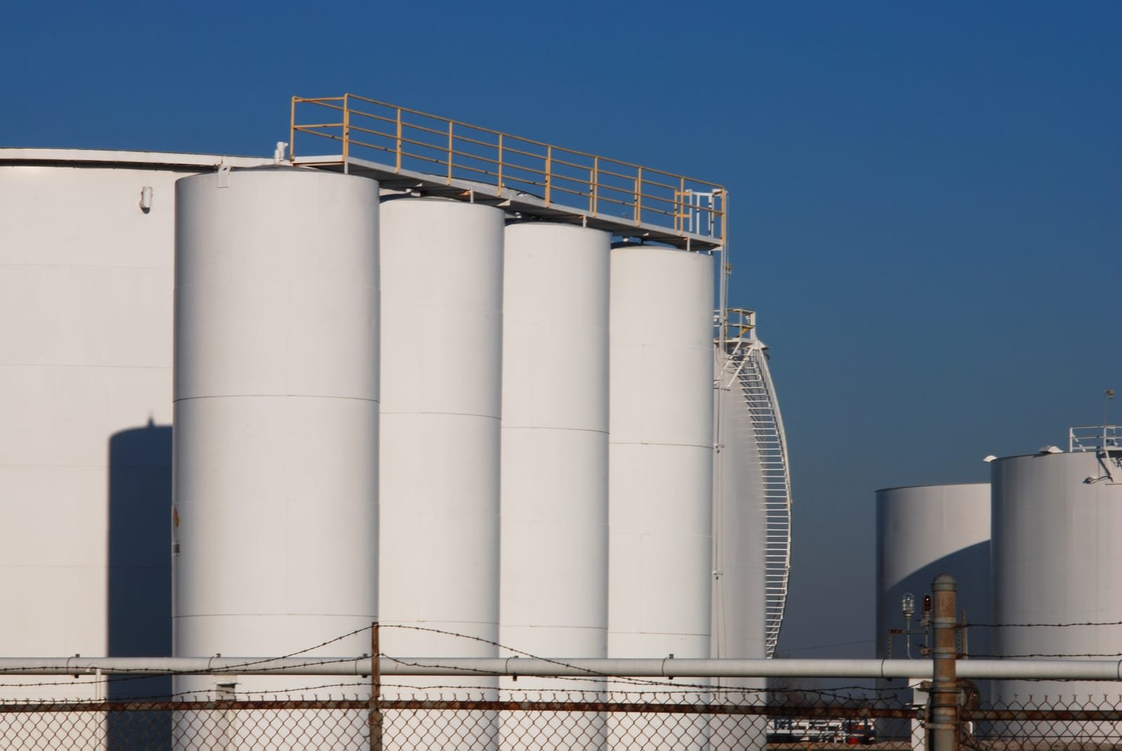 Storage tanks at an oil refinery, illustrating oil trading